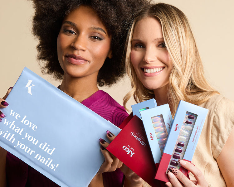 Two women smiling and holding Kleo nail sets and a mailer that says, “we love what you did with your nails!”