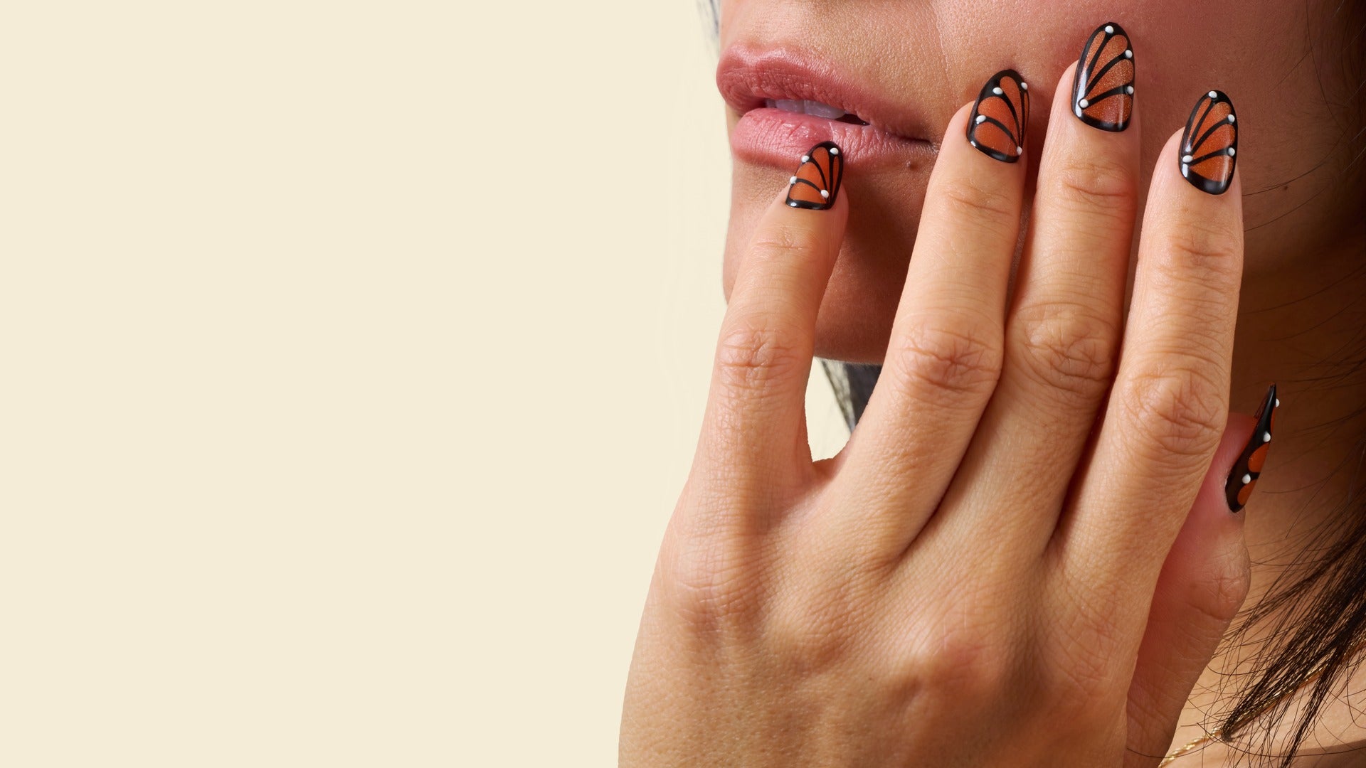 Close-up of magnetic butterfly-inspired coffin press-on nails with orange and black wing design.