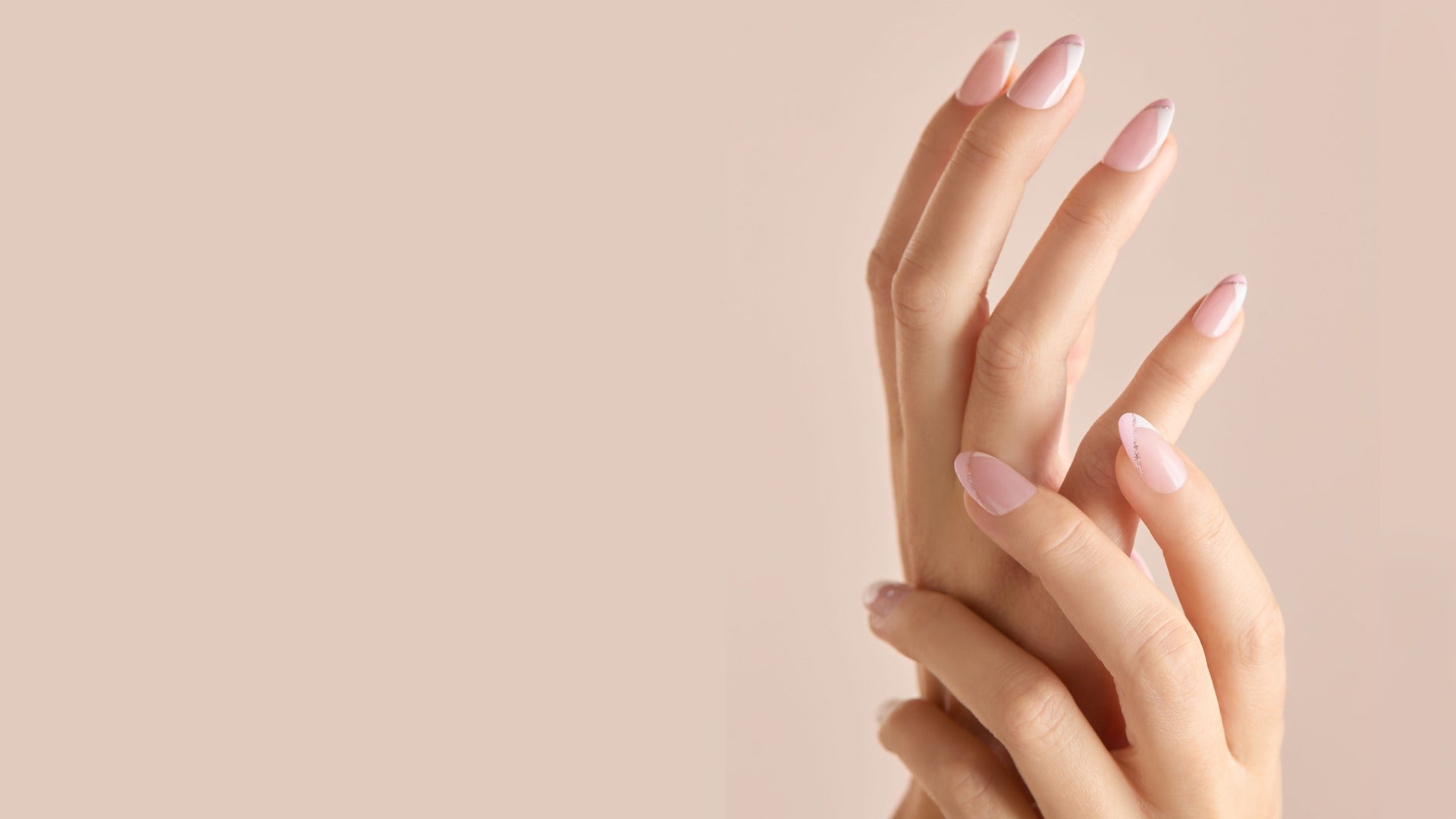 Hands showing pink press-on coffin nails with white French tips and subtle glitter accent.