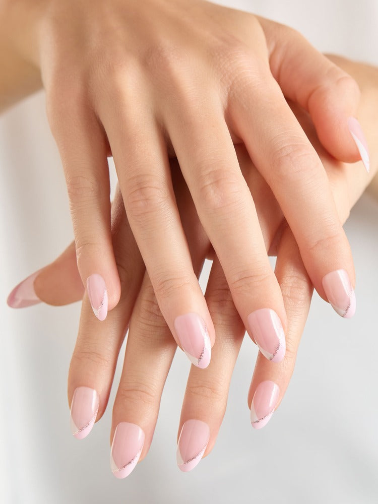 Hands showing pink press-on coffin nails with white French tips and subtle glitter accent.