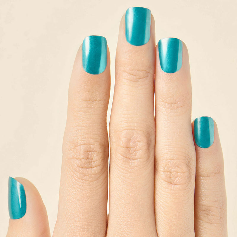 Hand with transformative teal chrome LED gel nail strips, fingers extended against a neutral background.