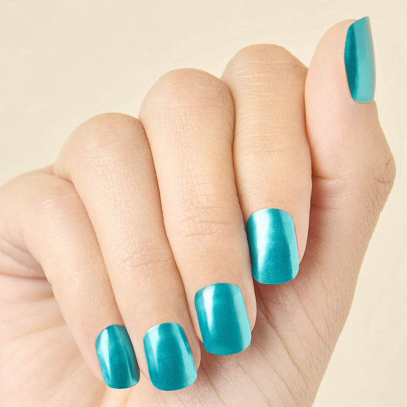 Hand with transformative teal chrome LED gel nail strips, curled inward to show the shine and coverage.