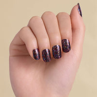 Hand with black multi colored glitter LED gel strips on beige background