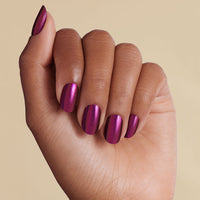 Burgundy purple chrome LED gel strips on hand with beige background