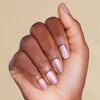 Hand with rose gold pink magnetic LED gel strips on beige background