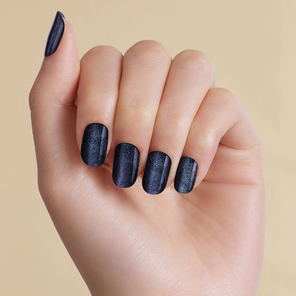Magnetic dark navy blue LED gel strips on nails with beige background