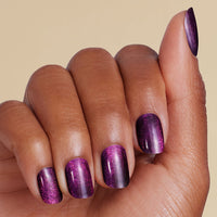 Hand with purple glittery LED gel strip on a beige background