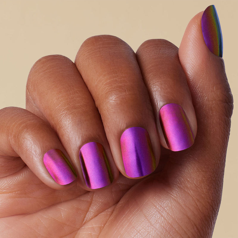 Hand with pink and purple chrome LED gel strip on a beige background