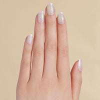 Hand with white and silver glitter LED gel strips on beige background
