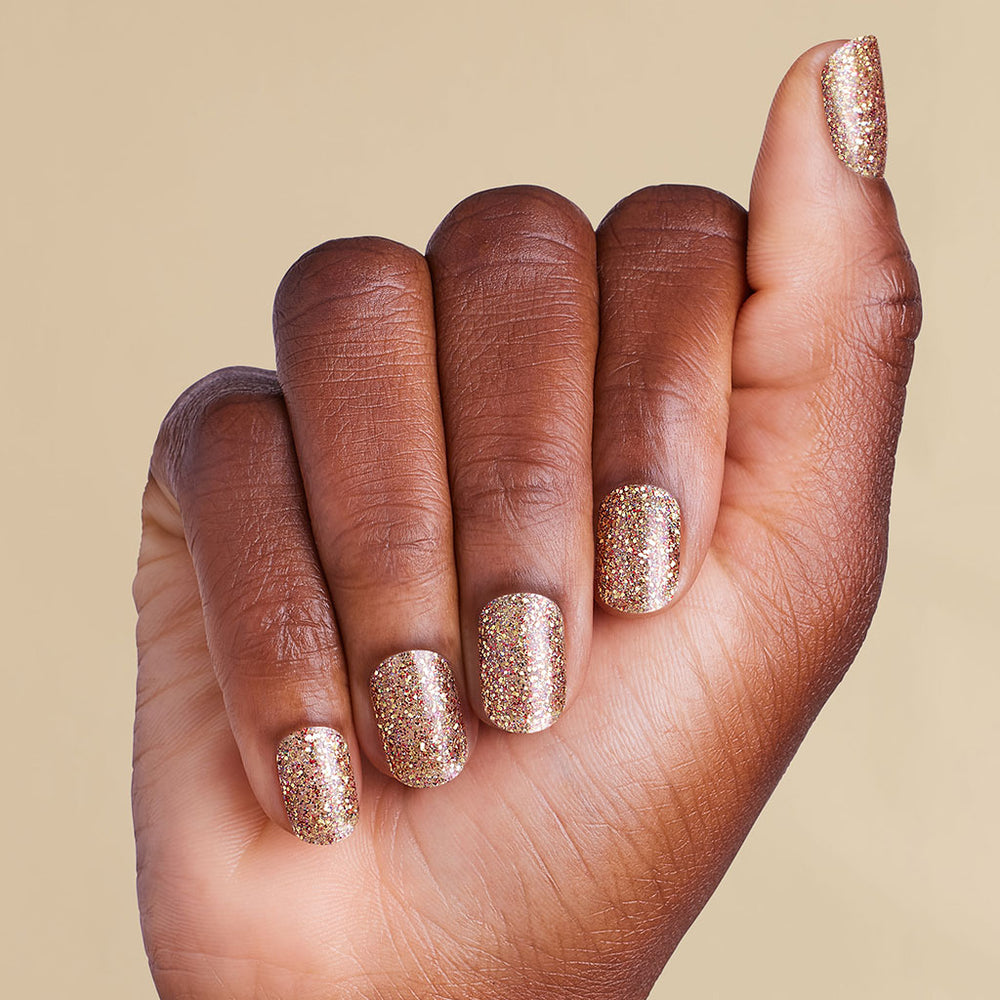 Hand with gold glitter LED gel strips on beige background