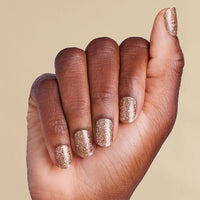 Hand with gold glitter LED gel strips on beige background