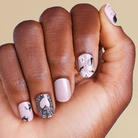 Hand with pink nails featuring black and pink nail art on LED gel strips