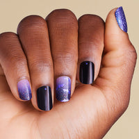 Hand with purple and black gradient Halloween bat nail art on LED gel strips