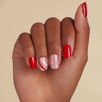 Hand with peppermint red inspired LED gel strips on beige background