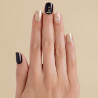 Hand with black and gold glitter snowflake LED gel strip nails