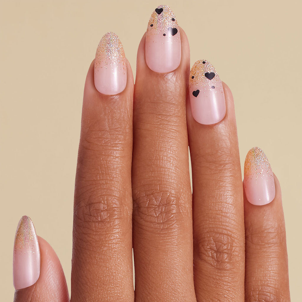 Hand with gold glitter ombre and heart design on coffin press on nails