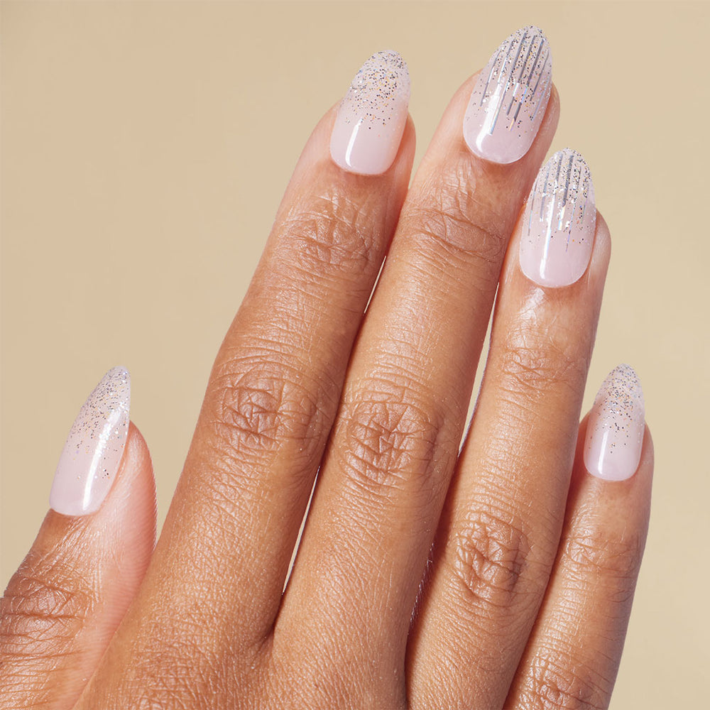 Hand with silver glitter almond press on nails with beige background